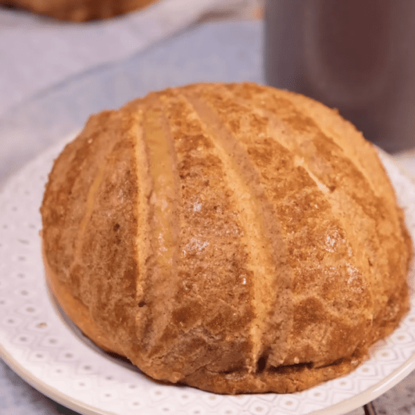 Freshly baked Conchas (Mexican sweet bread) next to a coffee mug, perfect for breakfast.